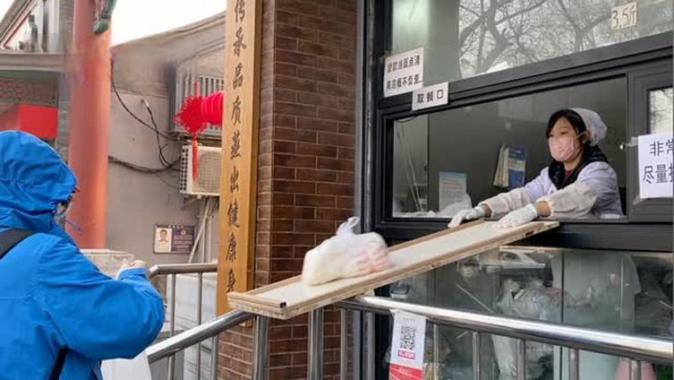 【疫情期间,馒头店滑滑梯式卖货,顾客:很有安全感】北京鼓楼附近,一家馒头店在售货窗口前支了