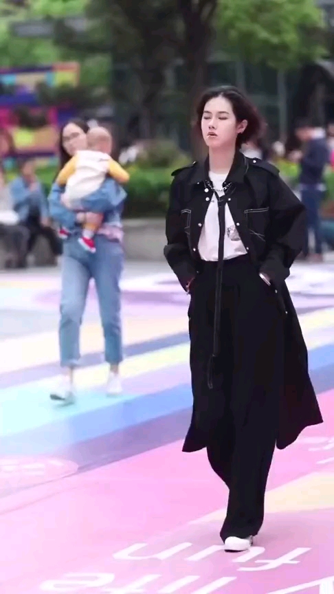 街头的美女嘴里叼着棒棒糖,打扮和气质超级