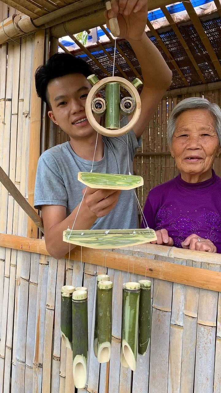 奶奶一个人望着窗外,小伙给奶奶手工制作一个竹子风铃,奶奶很开心。