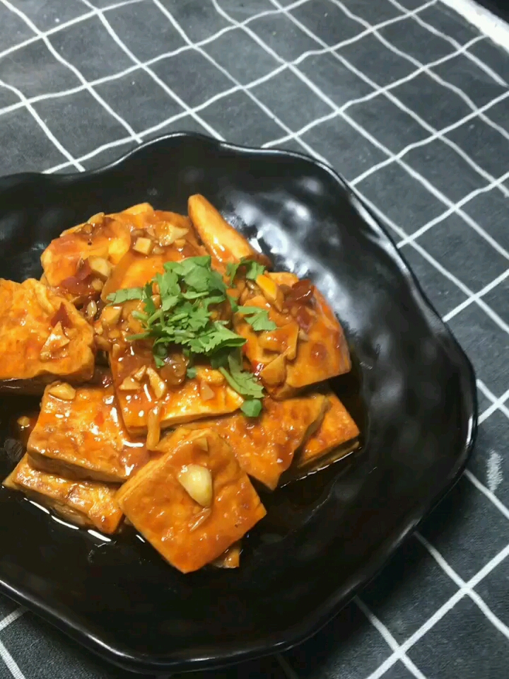 家常豆腐做法:豆腐切块煎制两面金色,耙到一边放蒜,豆瓣酱炒出红油加水末过豆腐,放