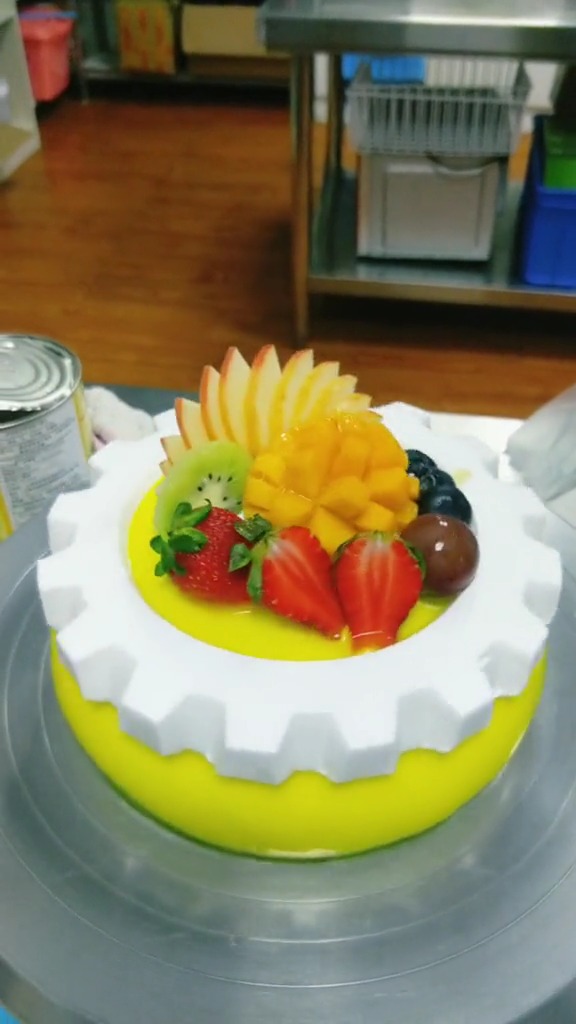 水果蛋糕一种摆法叫后高前低,就是先把水果从大到小从蛋糕后面位置开始依次摆起