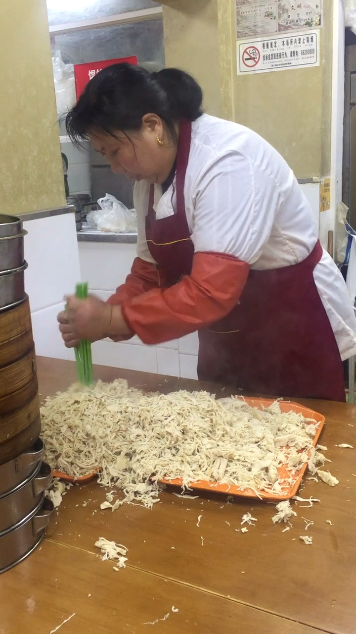 淮安市的两淮一绝鸡丝辣汤,员工正在把鸡肉块捣成鸡丝状。