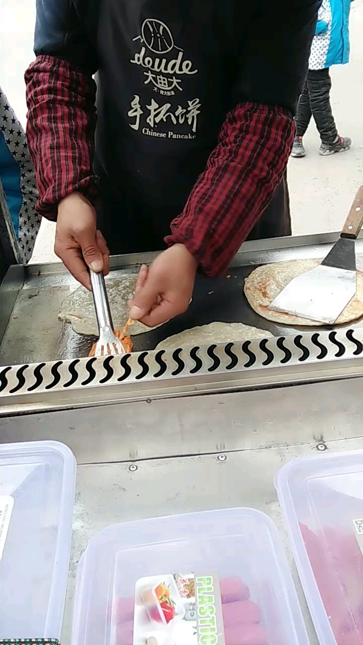 学校门口的手抓饼,三元一个,加鸡柳或者火腿就五元,加鸡蛋就多一元。 生意火爆!