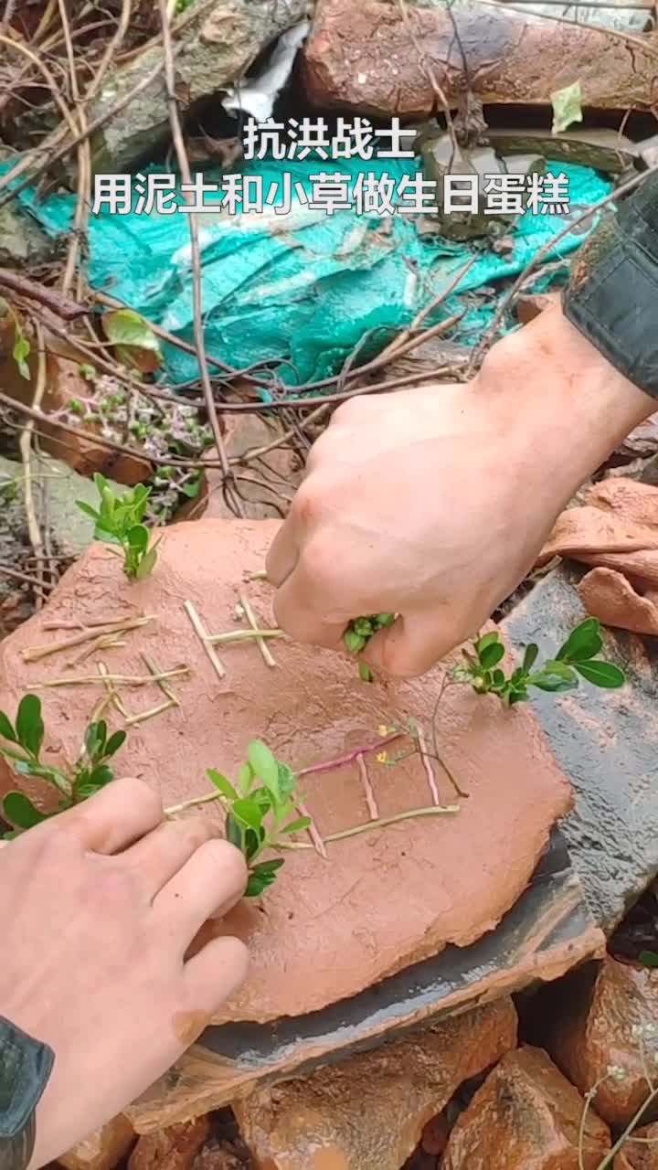 快乐就是这么简单又美好!战友们就地取材,用泥土和小草为抗洪战士做了一个“生日蛋糕”