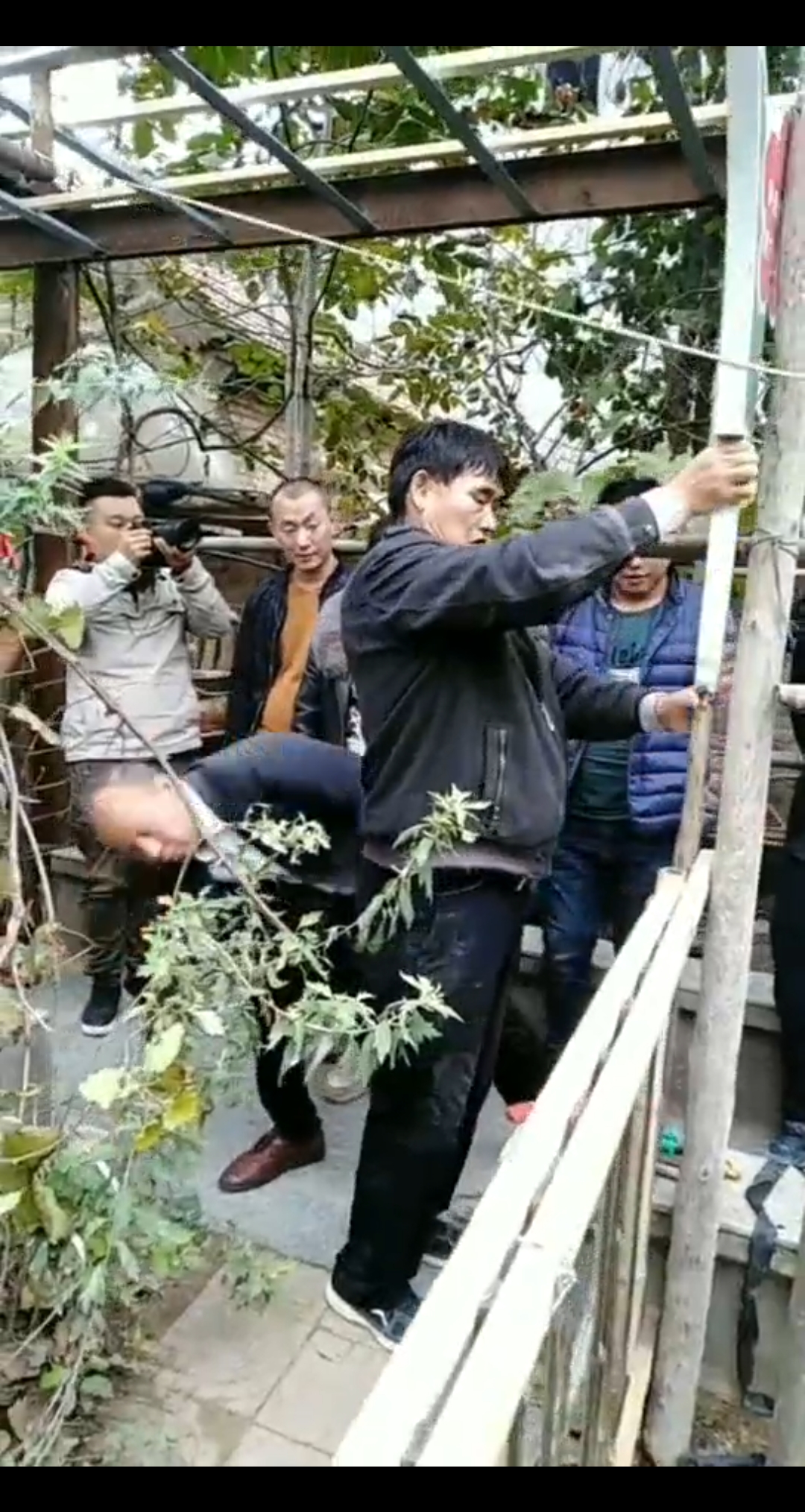 大衣哥在菜园里设一个指示牌