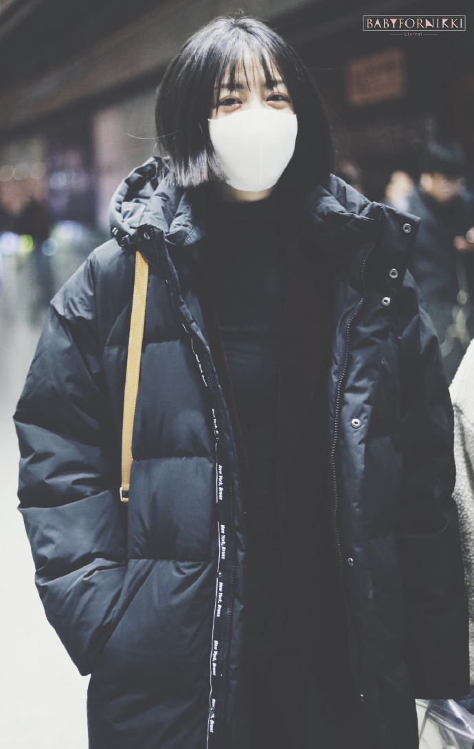 李溪芮戴白色口罩穿黑色长款羽绒服现身机场,穿着非常保暖了