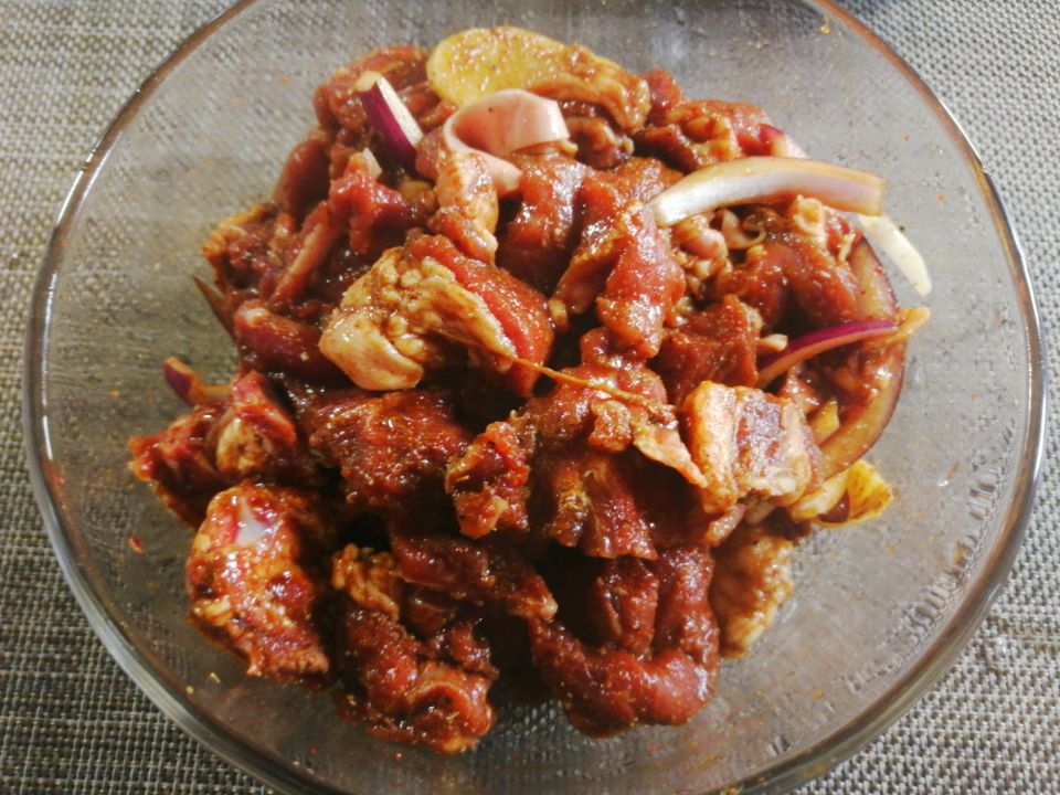 3,烤盘垫一张锡纸,倒入腌制好的羊肉,再加入土豆块,青红辣椒和洋葱