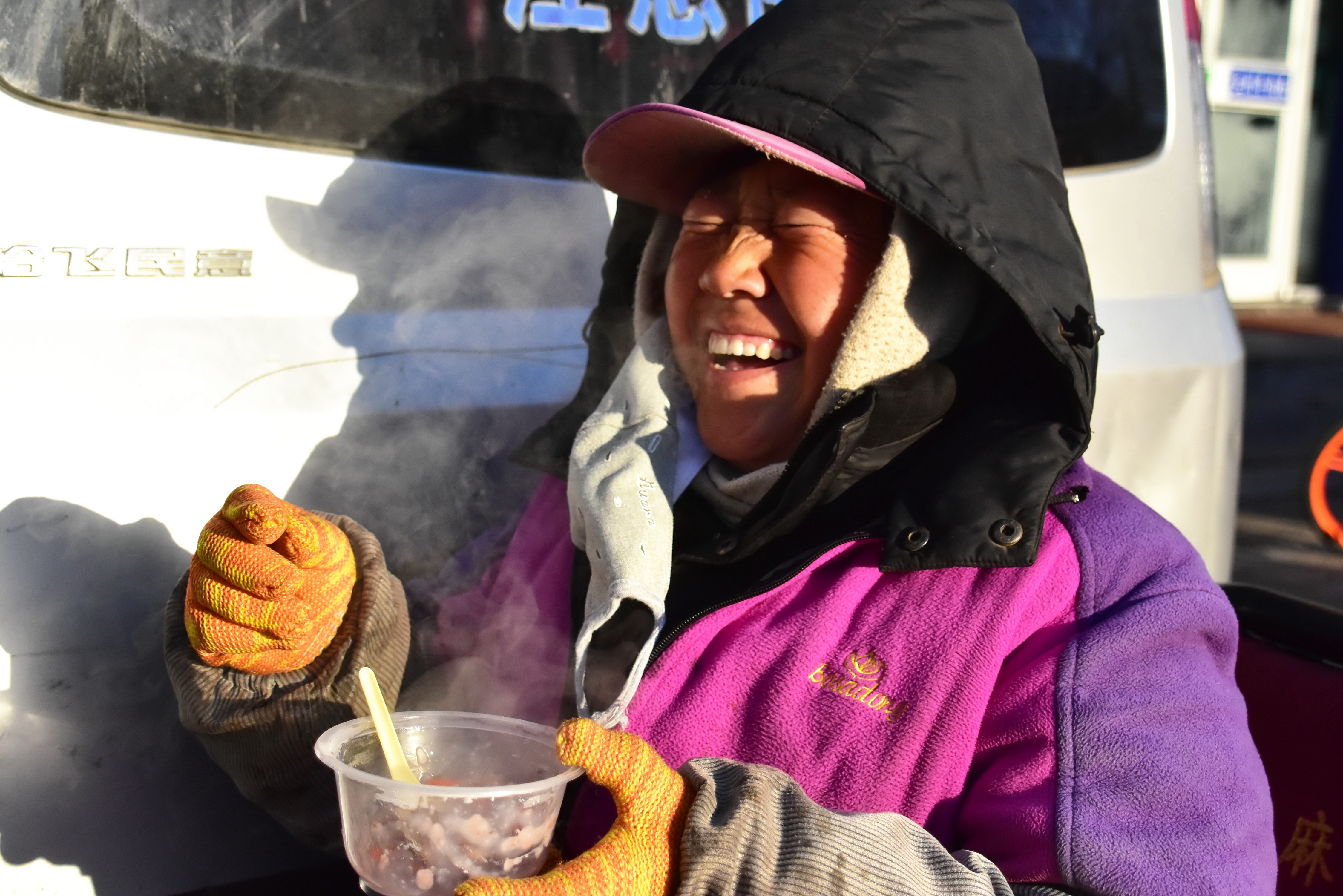 这位推着车的环卫工人,被招呼到跟前,领了一份腊八粥,一份馒头,还有