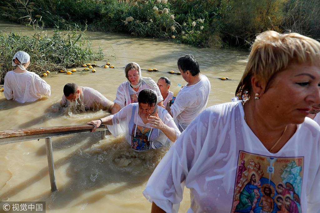 约旦河西岸:基督教朝圣者在泥水中受洗 庆祝主显节