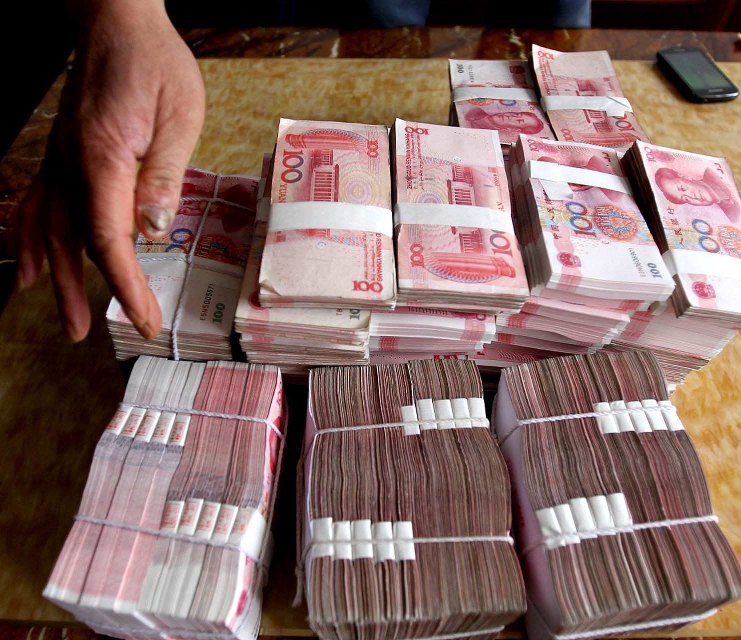一位年轻小伙在入住一家宾馆时,意外发现了抽屉里摆放着10万元现金