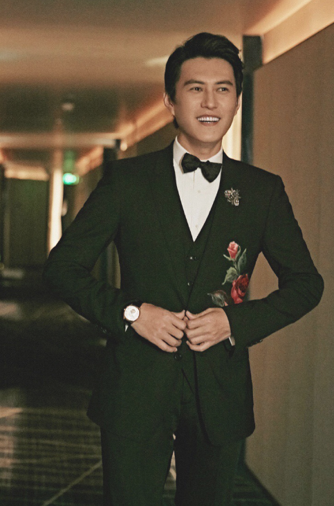 靳东气质率性的发型,白衬衫黑领带身穿黑色刺绣西服套装,下身一双黑