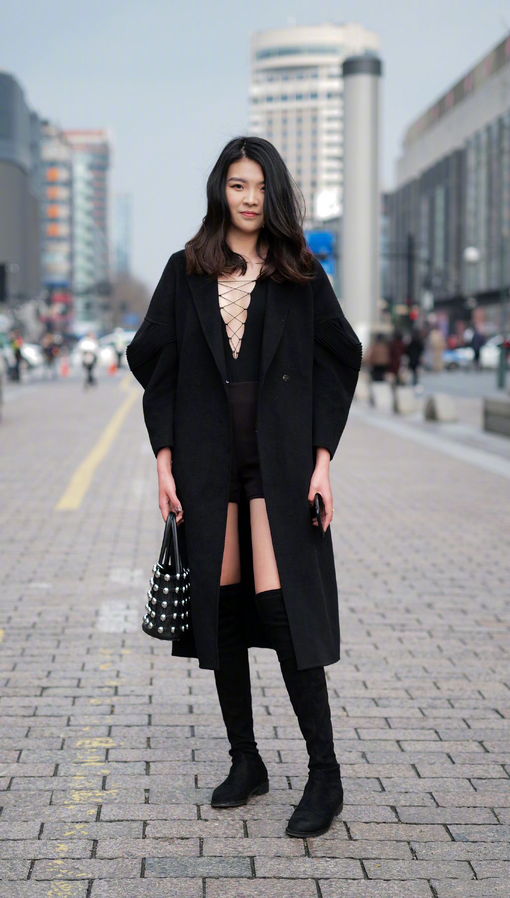 街拍:美女短裙加长筒的靴子,显大长腿,黑色的大衣显瘦!