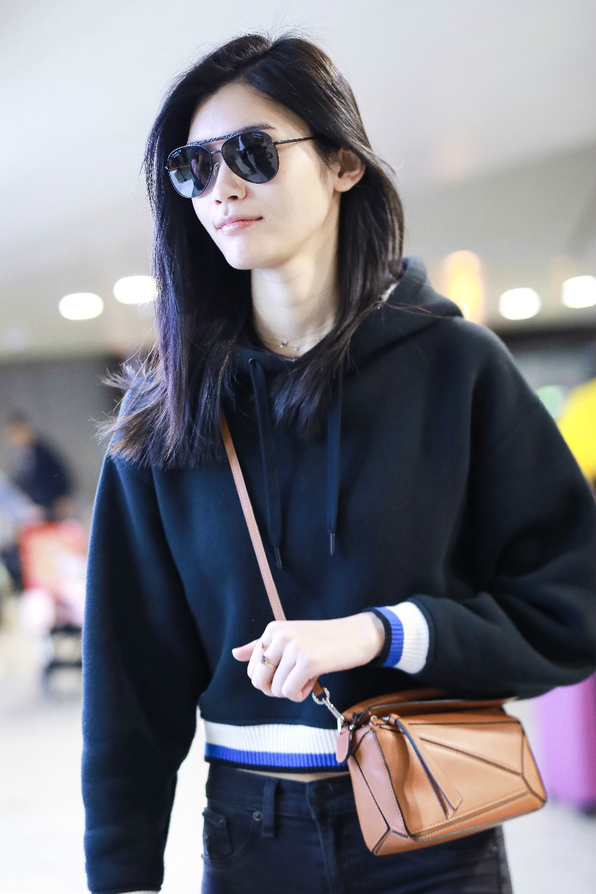 奚梦瑶戴墨镜穿黑色卫衣搭配黑色裤子现身机场,皮肤白皙笑容灿烂