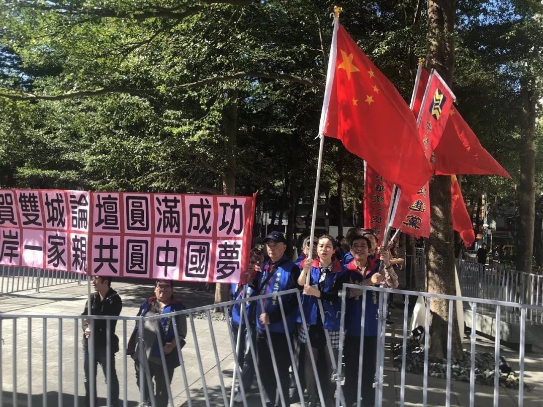 的"中华统一促进党"成员举着五星红旗,大喊"两岸一家亲,共圆中国梦"