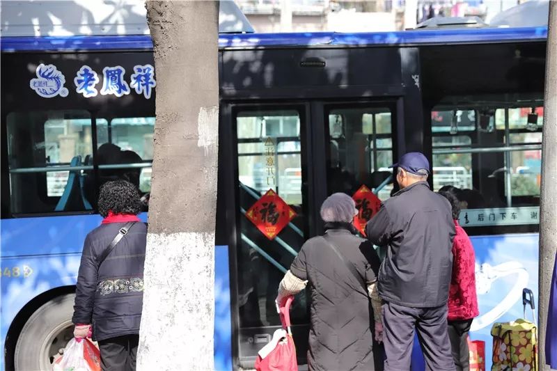 公交车自动门上也贴起了红色的窗花.