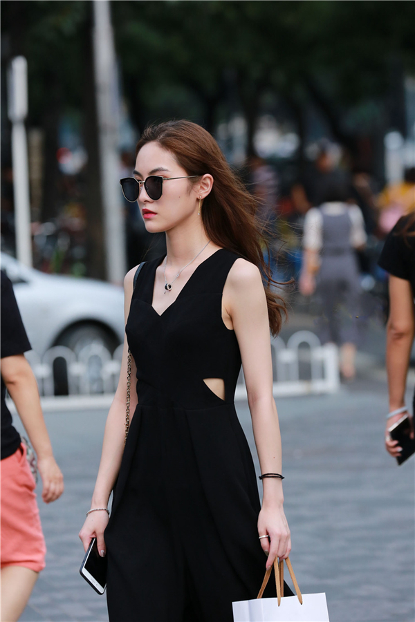 一身黑色的美女,戴着墨镜,走在大街上,显得冷酷又高贵.