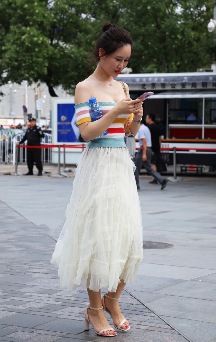街拍:美女身穿白色包臀裙,大秀修长美腿,走在街头,回头率爆棚