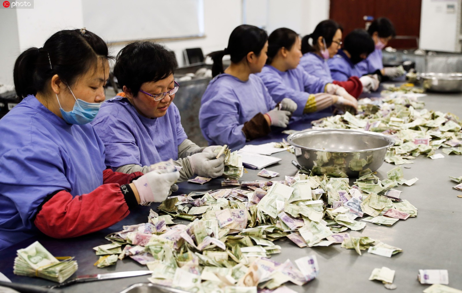 着统一着装的点钞员分拣,点钞,复核,结算,打包,装捆