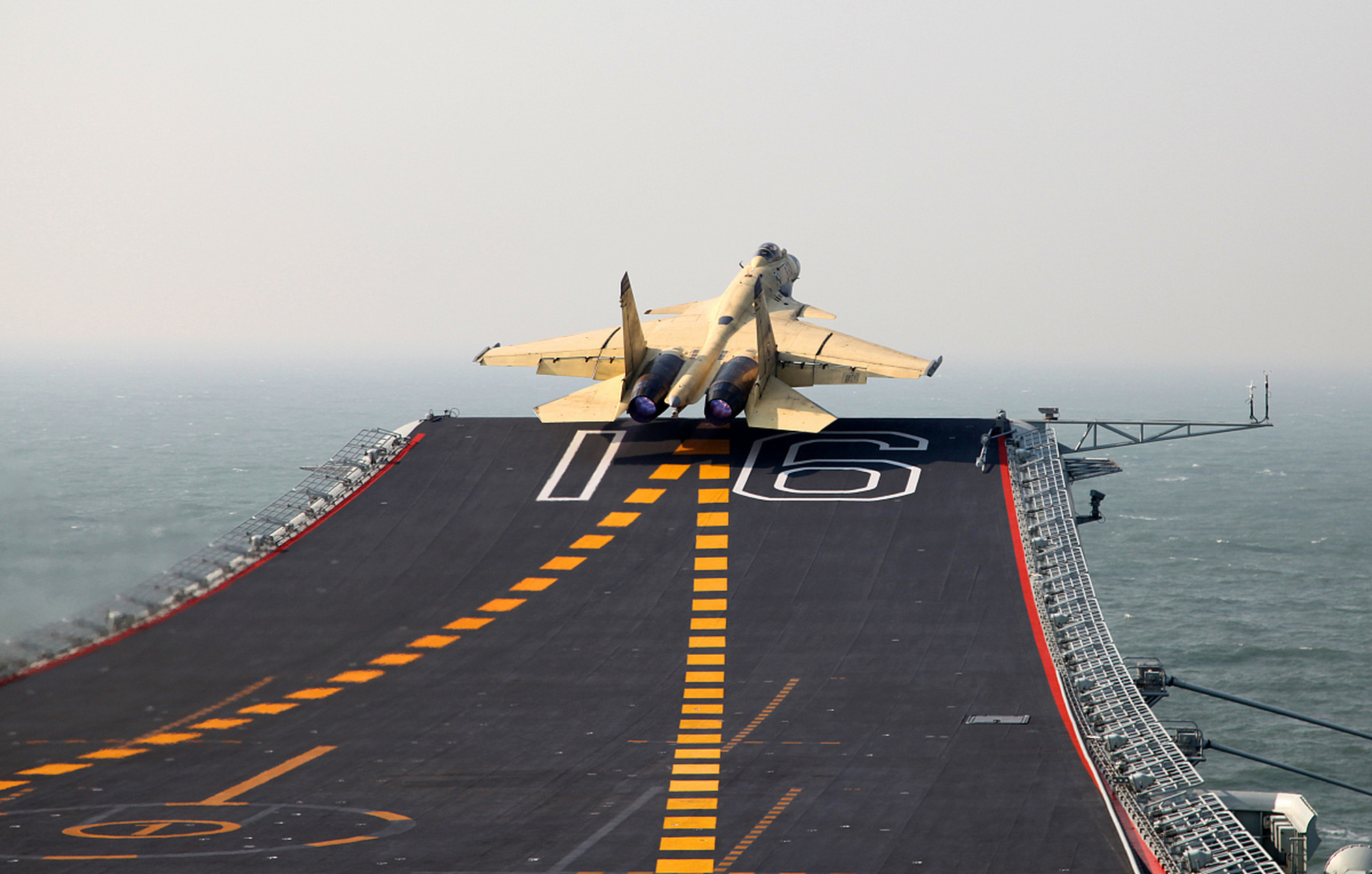 歼15采用滑跃起飞,不可能像弹射起飞满油满弹,歼15半油半弹,作战半径