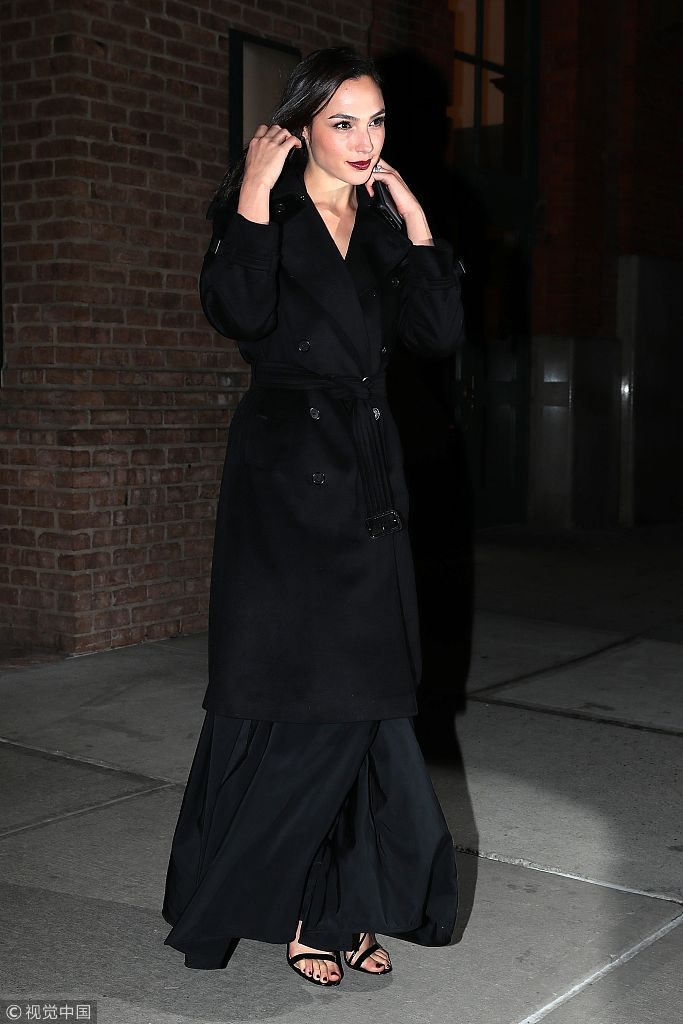 盖尔·加朵黑色大衣一字带凉鞋 全黑装扮映衬好肤色
