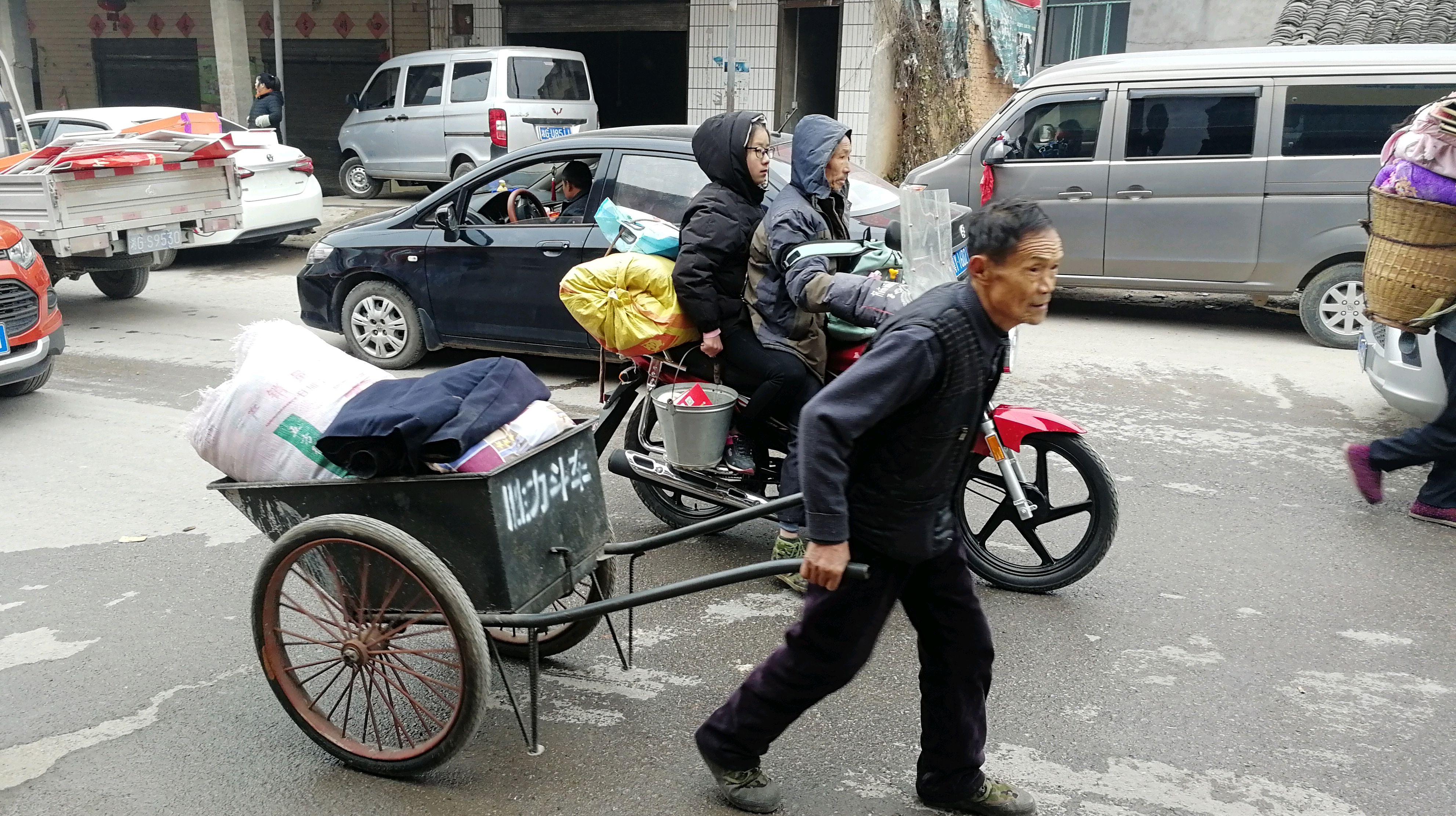 一位父亲用斗车拉运孩子的行李