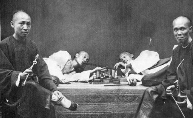 图为烟馆里吸食鸦片的男子,他们还找了一名歌姬一起吸食鸦片.