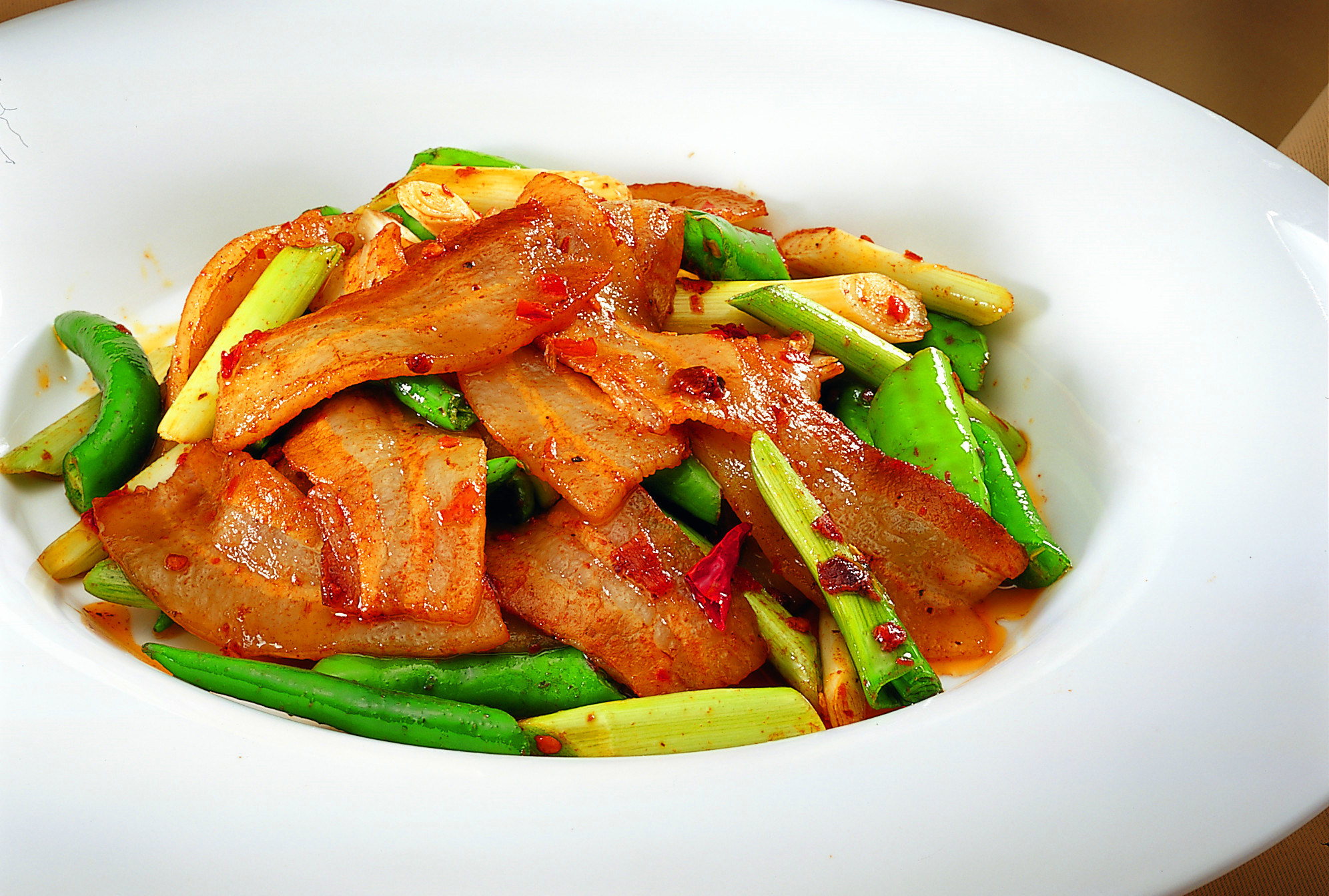 莲花小炒皇:把莲花白切成块型,倒入合适的油,放入小辣椒,花椒,姜片,蒜