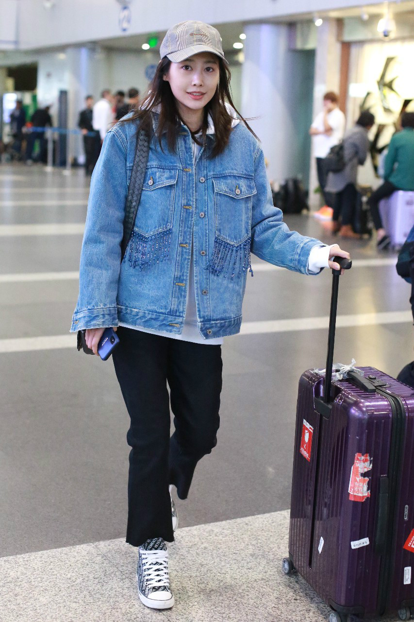 李纯穿蓝色牛仔衣搭配黑色喇叭裤现身机场,皮肤白皙笑容灿烂