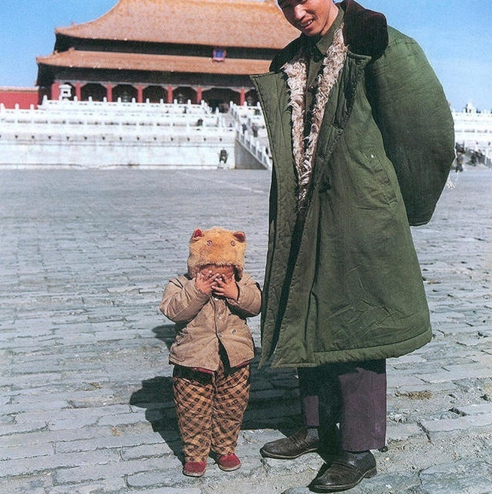 带着孩子游览故宫博物院的年轻父亲.