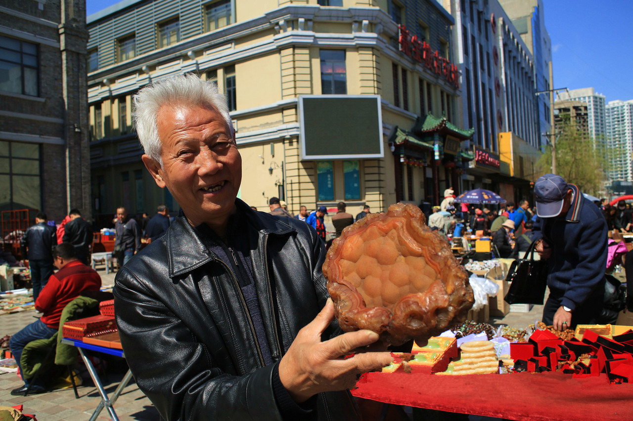 他在摊位上叫卖石头,其中这块叫卖10万,只因石上有这个字