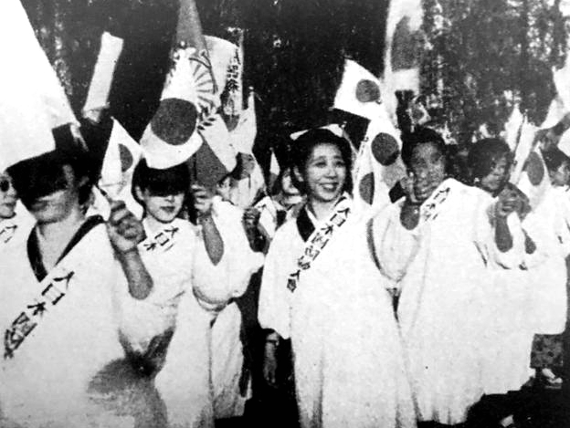 在南京被攻陷后,日本的女性举着小旗在街头走,庆祝