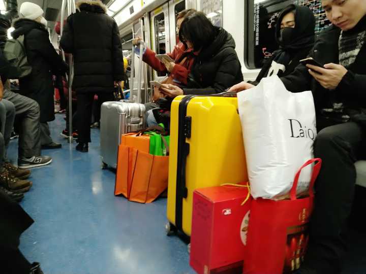 北京春运返乡潮 地铁人守一份旅行箱