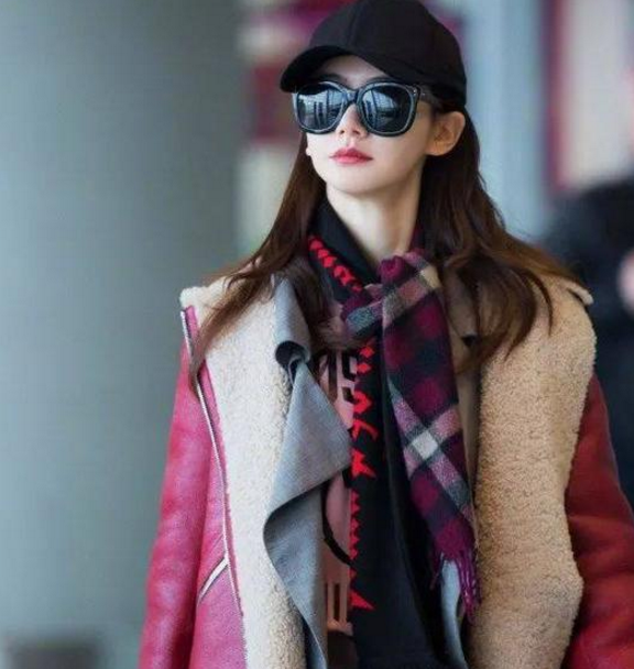 高圆圆搭配一条深蓝色的围巾,身穿一件雾霾蓝色的长款外套现身机场