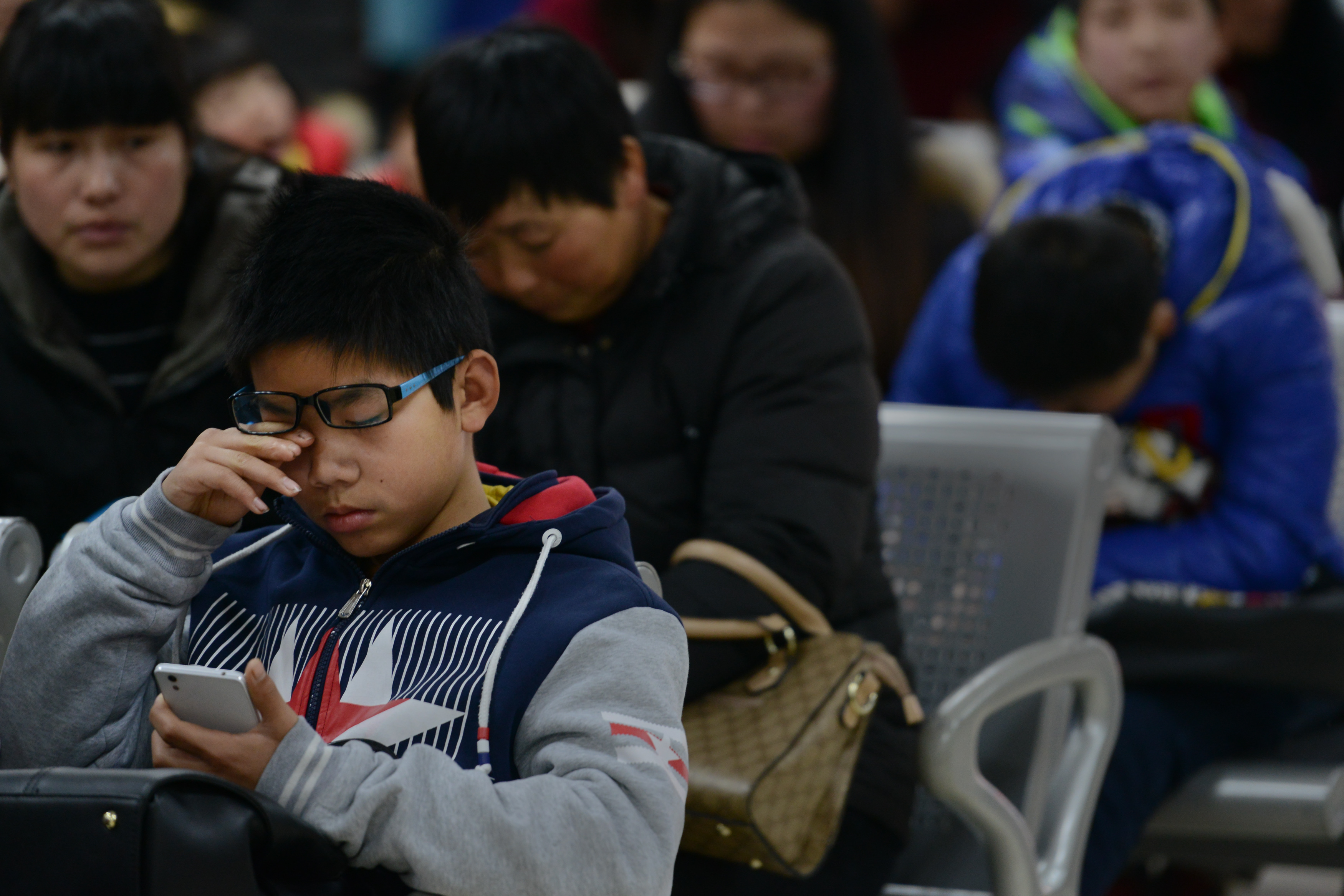 儿童低头族抱着手机看医生 过个春节近视100度