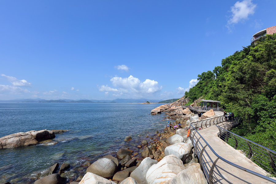 小梅沙三面青山环抱,一面海水蔚蓝,一弯新月似的沙滩镶嵌在蓝天碧波