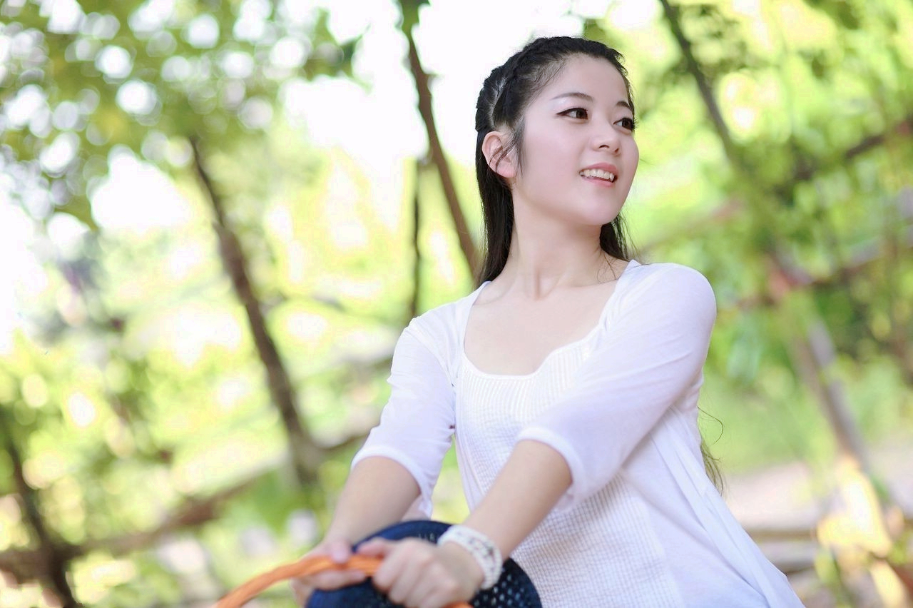 在公园里荡秋千的开心美女姑娘!