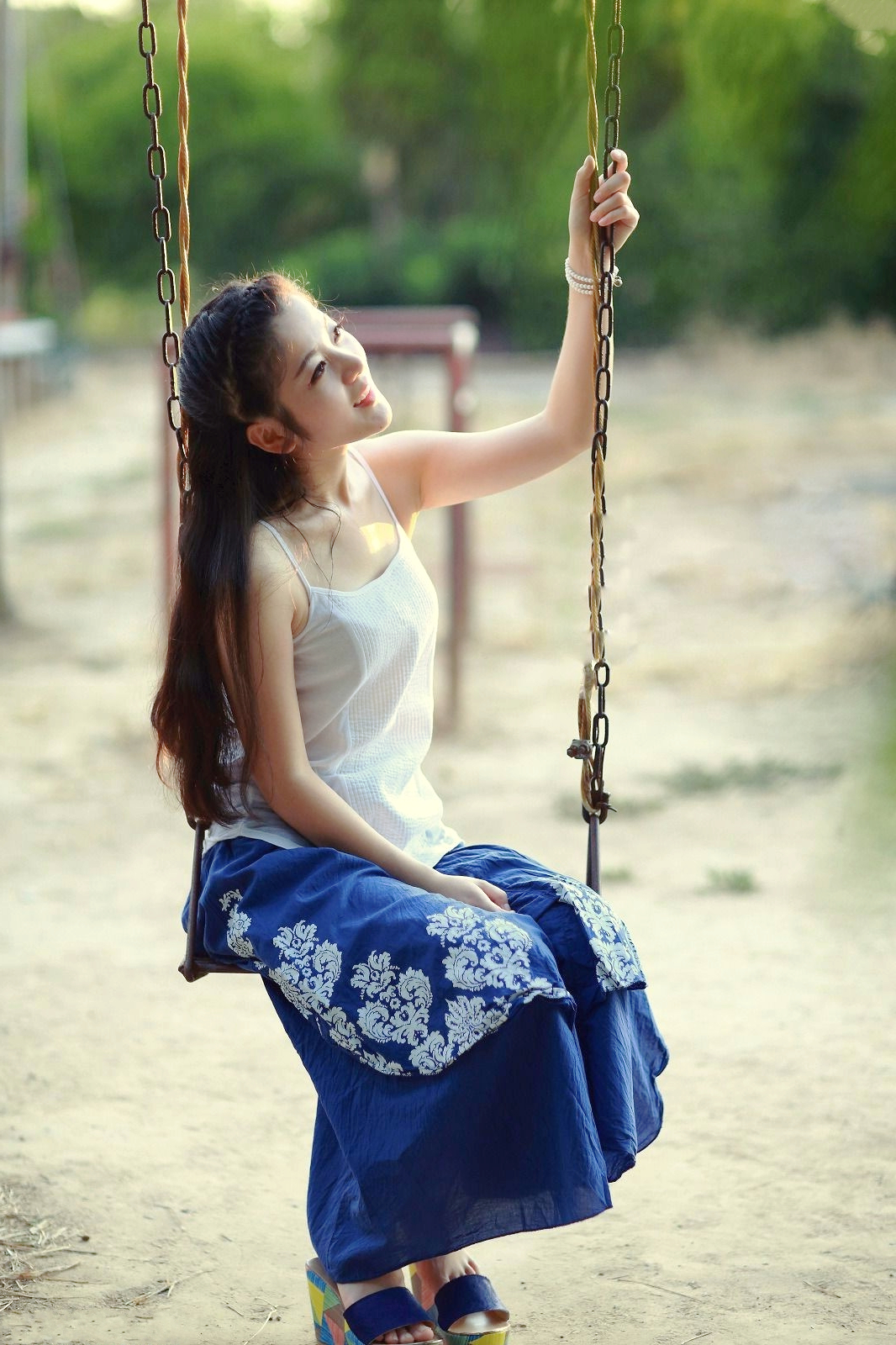 在公园里荡秋千的开心美女姑娘!