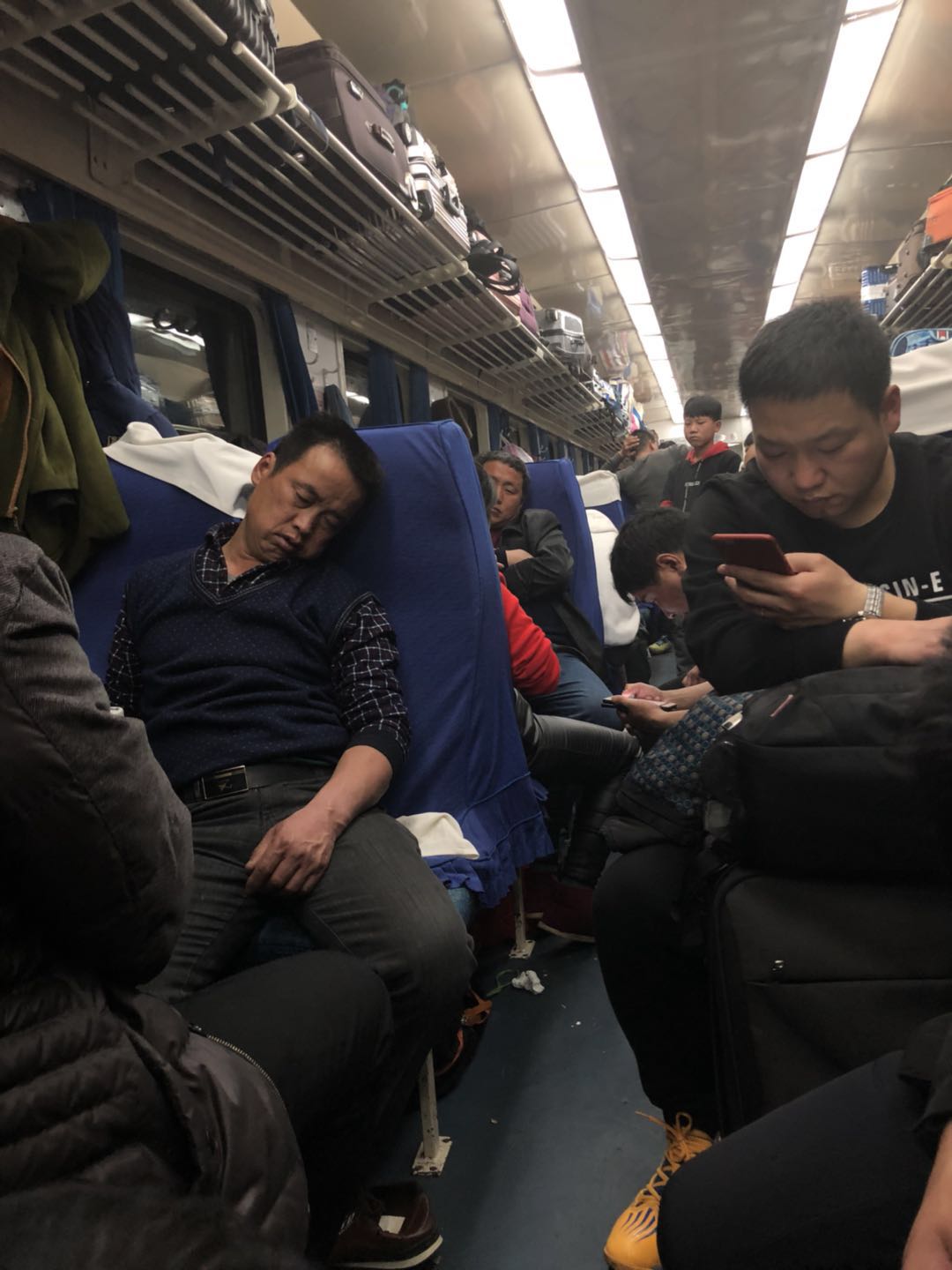 春运期间在拥挤的绿皮火车厢内,母亲彻夜不眠也要让孩子睡好