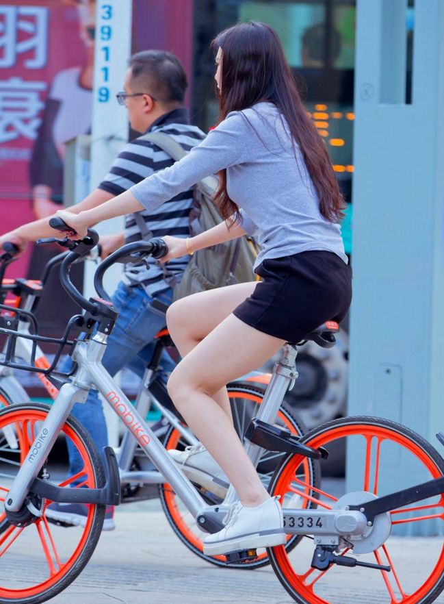 成都街拍:灰色t恤加黑色休闲热裤的美女,骑自行车等红绿灯