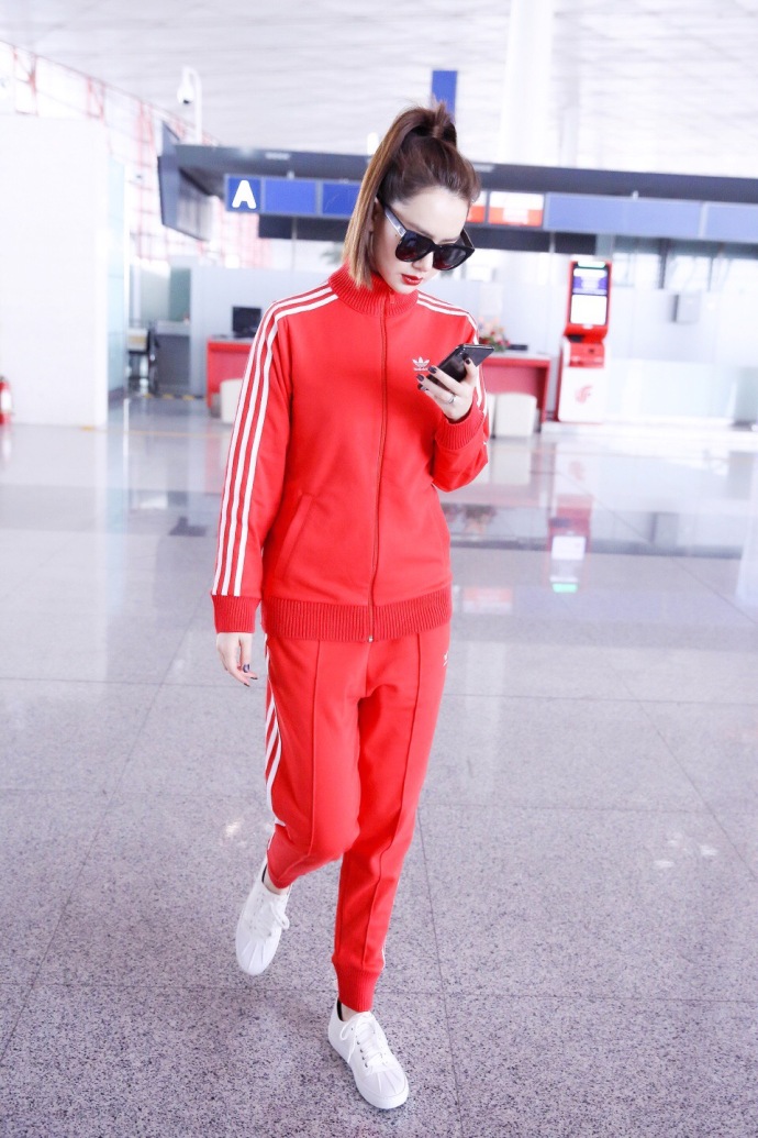 戚薇扎马尾运动装戴墨镜现身机场白到发光,一路玩手机变身低头族