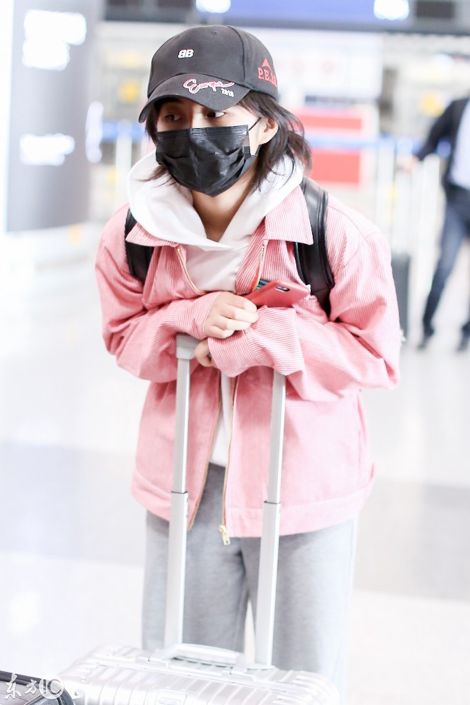 张子枫戴口罩穿粉色外套搭配灰色阔腿裤现身机场,看起来略显疲惫
