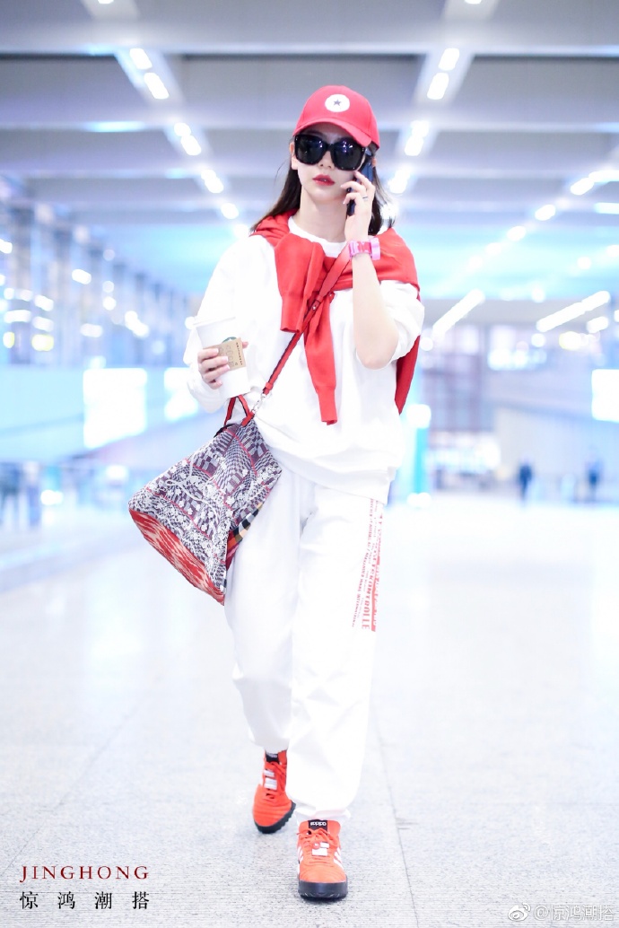 戚薇红唇戴墨镜穿白色运动装现身机场,一路上打电话聊个不停!