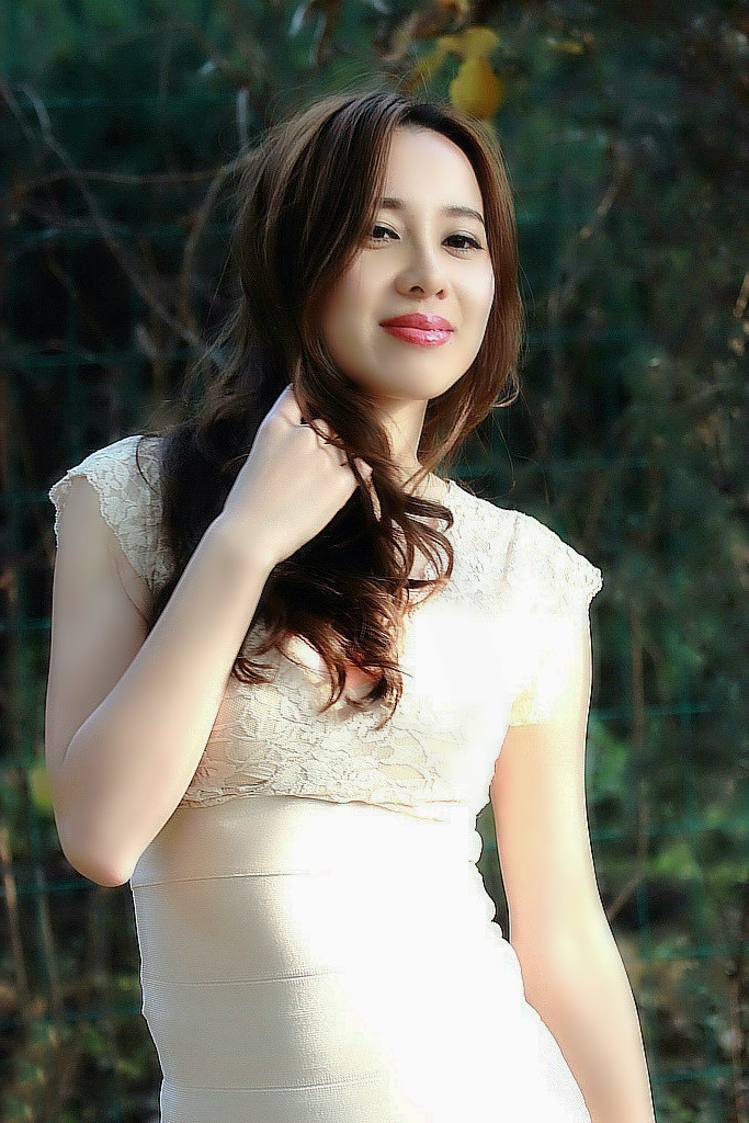 公园里阳光下的开心笑容美丽女子!