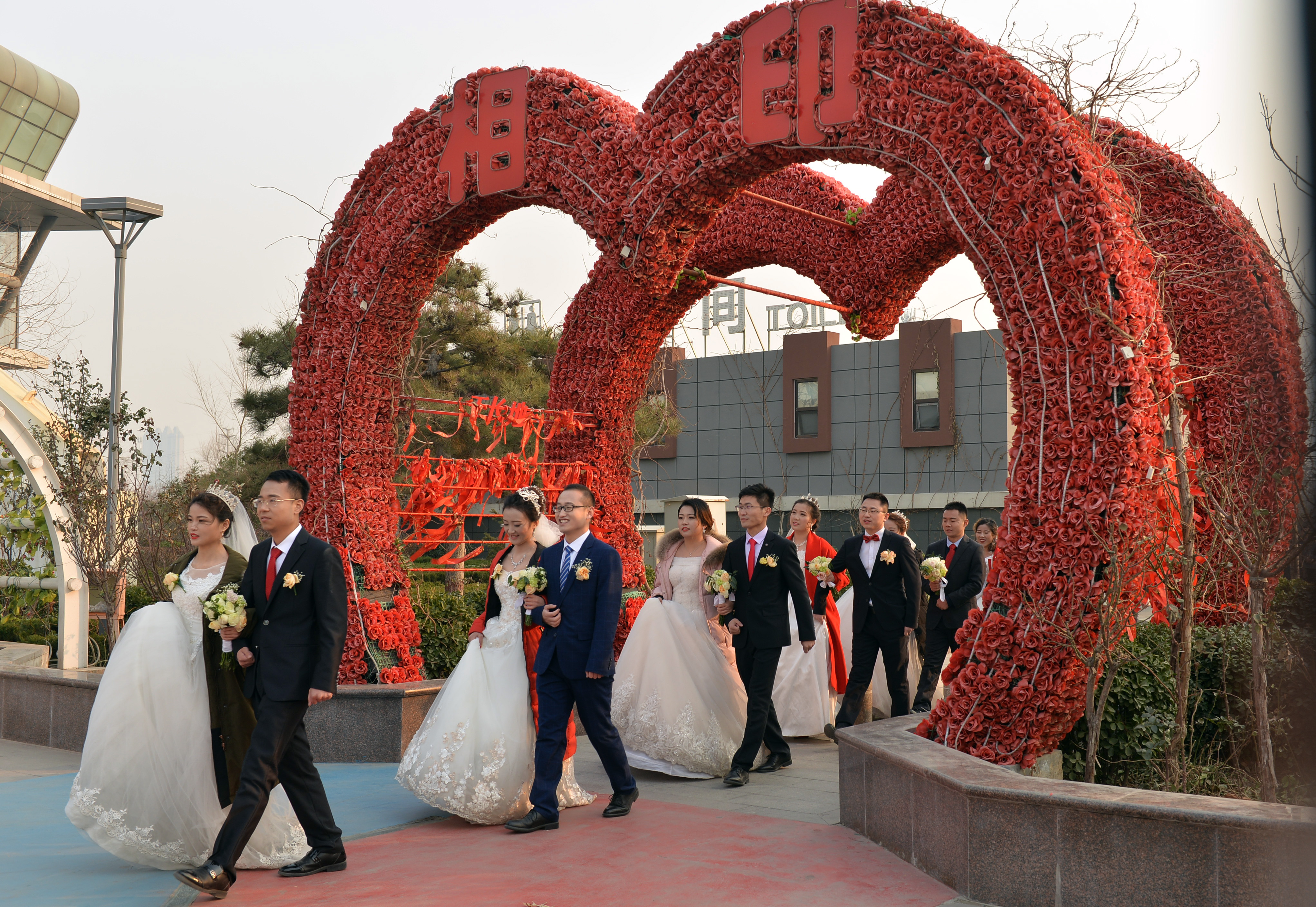 1月2日,参加集体婚礼的新人在户外巡游.