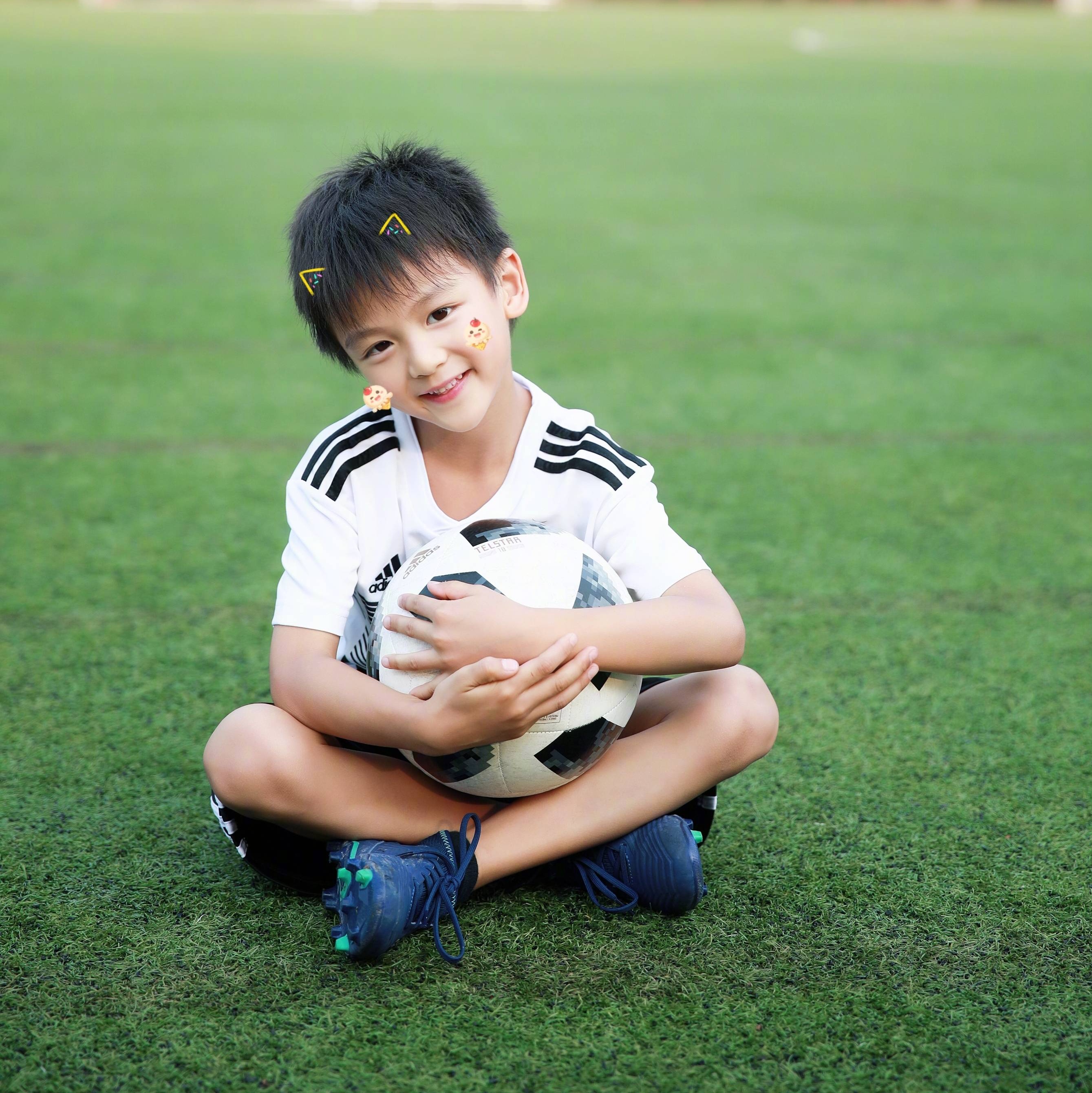 森碟和弟弟小亮仔在足球场玩耍,为世界杯加油