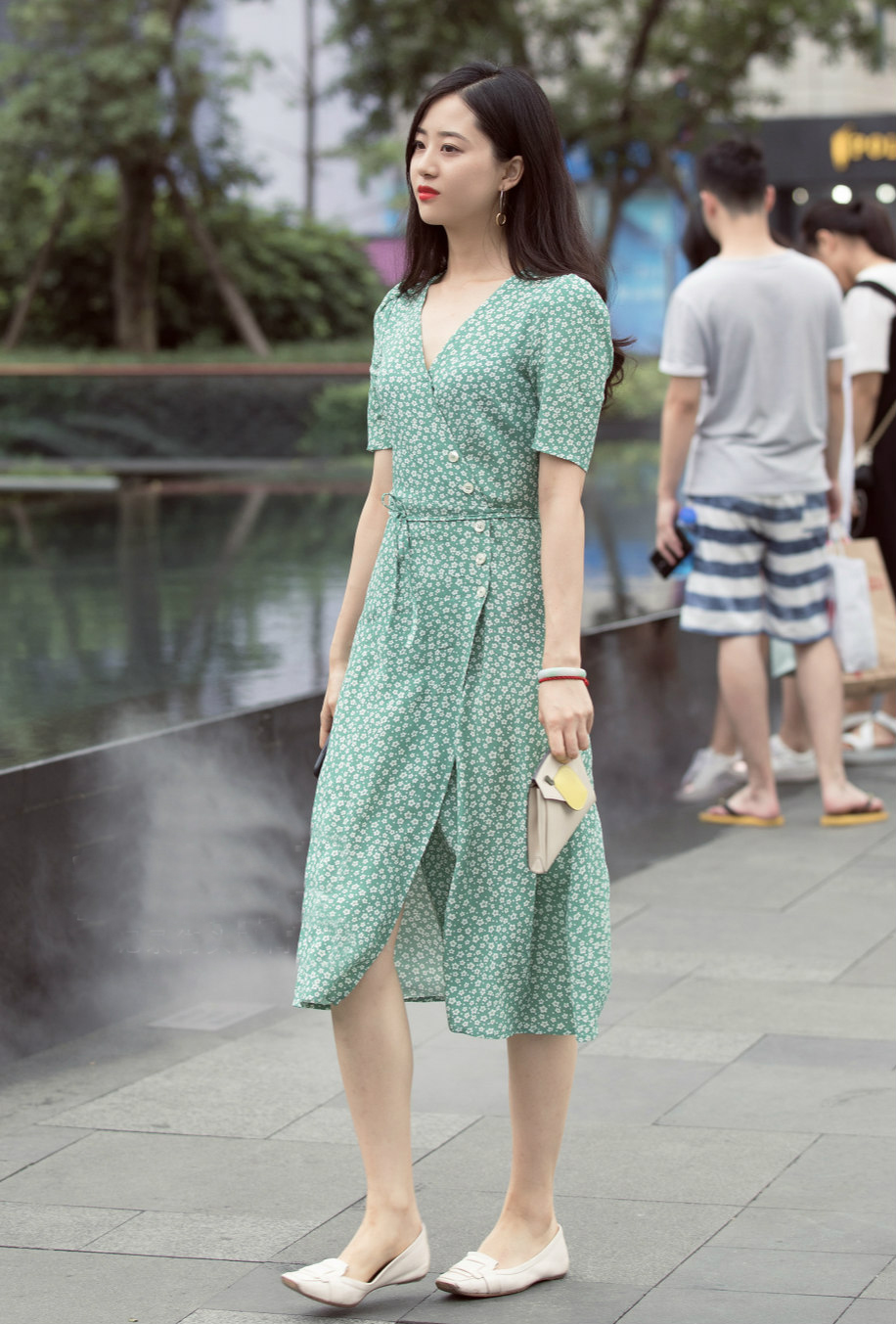 年轻辣妈的装扮青春时尚,蓝色有光泽的吊带上衣,秀出了好身材,白底黑