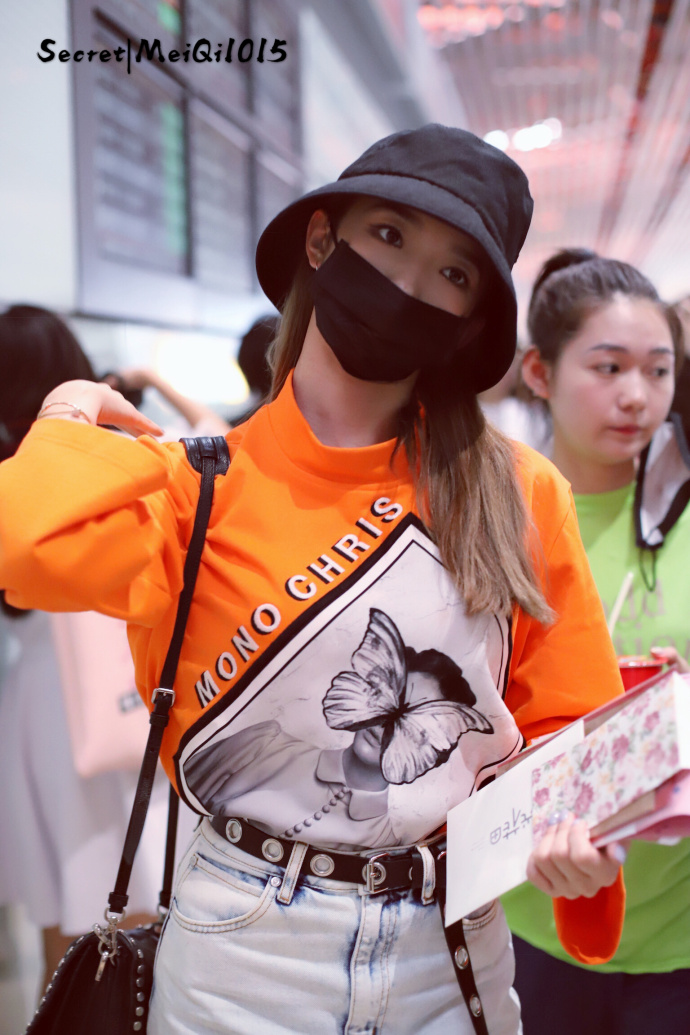 孟美岐戴渔夫帽和口罩穿橙色卫衣现身机场,用手比心卖萌好可爱!