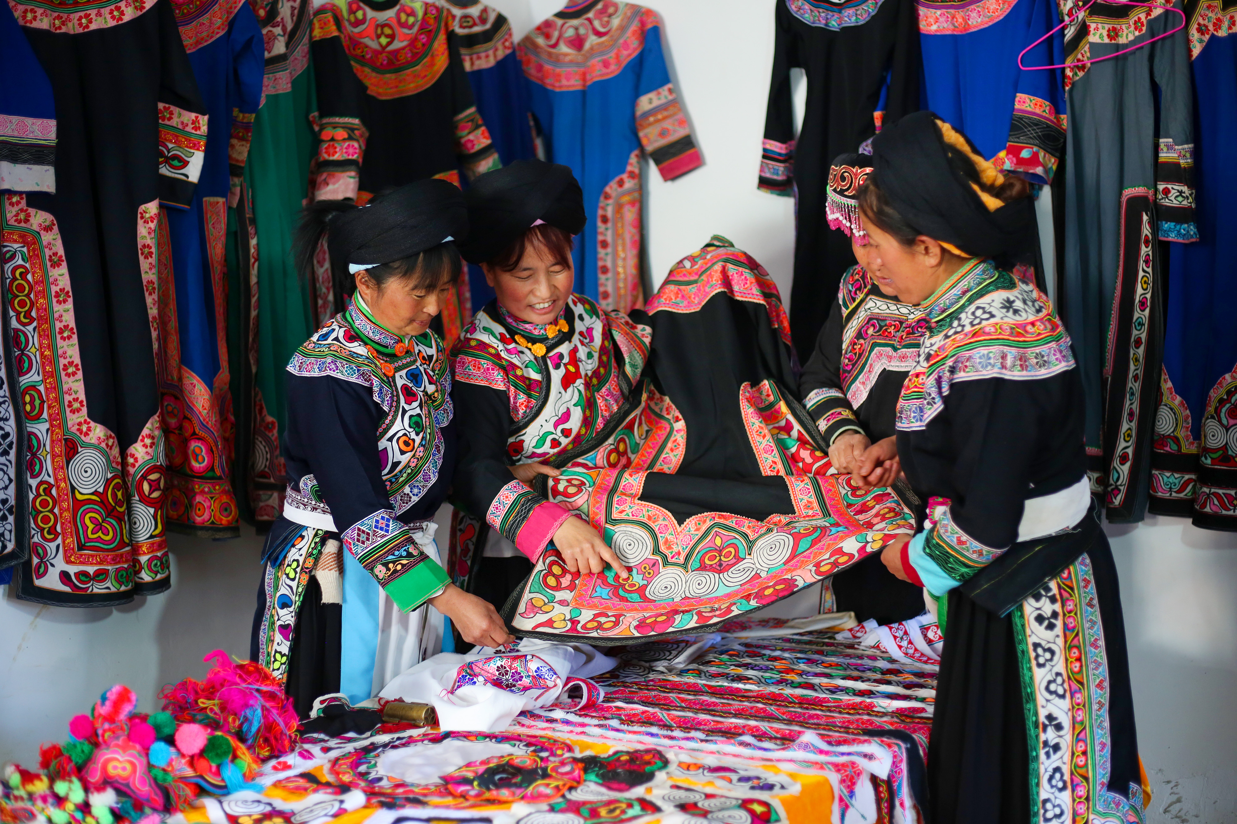 在贵州省威宁县龙场镇龙丰社区,唐柱姐(左二)和姐妹们交流服饰图案