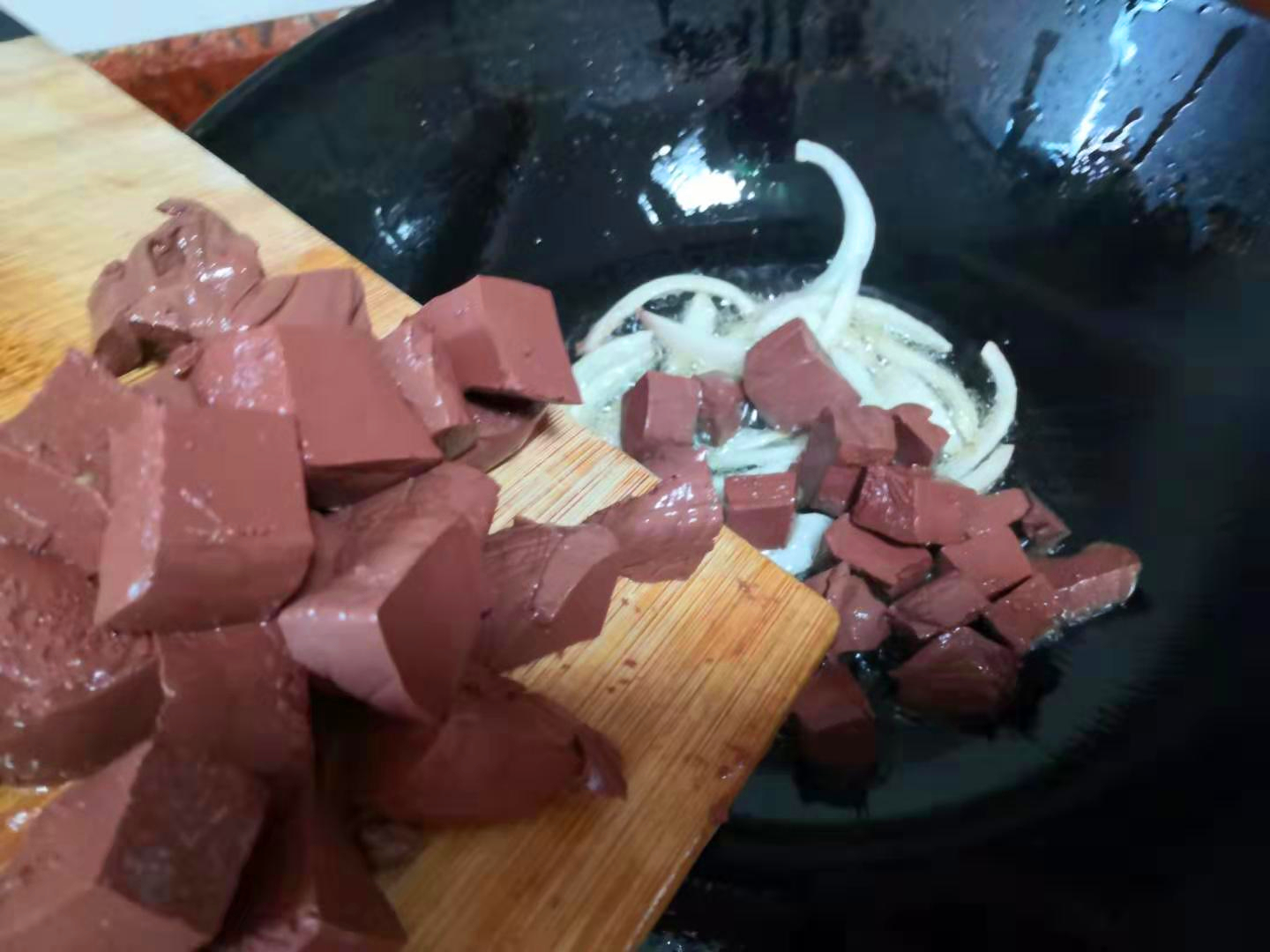 3,当锅中的洋葱被爆香好后,即可将我们的猪血放入锅中.