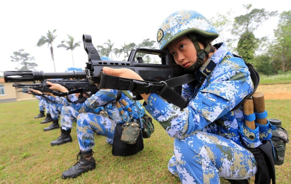 日本女兵,该女兵正在擦拭装甲车,应该是陆军装甲部队,头发挽起撸起袖